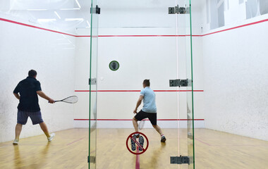 Squash player in action reaching on squash court. Squash Players on Tournament. Sports equipment...