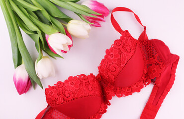 Women's red underwear with a bouquet of tulips on a white background. Festive and romantic mood for...