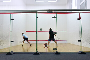 Squash player in action reaching on squash court. Squash Players on Tournament. Sports equipment...