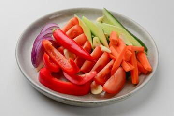 Platter of assorted fresh vegetables cut. Healthy raw veggies salad. Over white background.