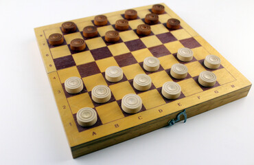 Wooden checkers on a wooden board on a white background. Game for two. Thinking game