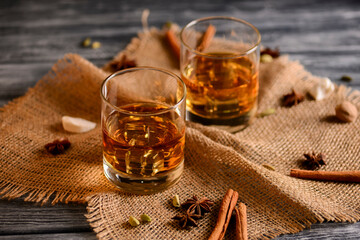 Scotch on wooden background. Whiskey in shot glasses. Black background.