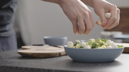 man make salad with kale, mozzarella, avocado and cherry tomatoes, add mozzarella
