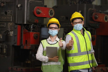 Team of engineer in full safety equipment with facial mask is working and showing thumbs up inside...