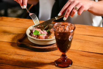 Dinner at Georgian restaurant. Eating out concept, eating BBQ fiery sausages with vegetables.