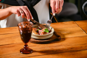 Dinner at Georgian restaurant. Eating out concept, eating BBQ fiery sausages with vegetables.