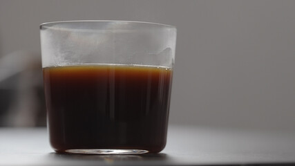 pour coffee in tumbler glass on concrete countertop with copy space