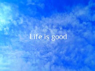 Inspirational qoute - "Life is good" over blue sky with fluffy clouds