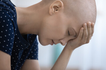 Close up of upset sad young Caucasian bald woman struggle with oncology feel depressed with bad...