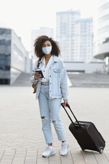 Young woman tourist holding passport and ticket, girl wearing protective face mask in a city, Business travel during pandemic, corona virus protection, healthy lifestyle, people, tourism concept