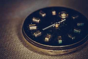 Vintage grunge background of an old clock. Abstract texture covered with dust, dirt, scratches. Macro photography in light tinted
