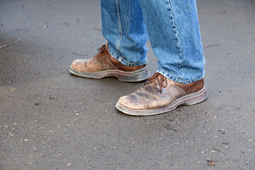 Man's legs in blue denim jeans and brown boots.