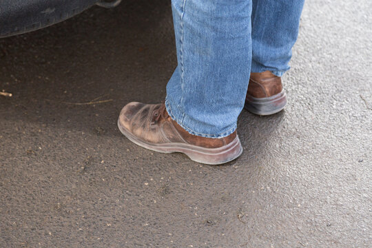Man's legs in blue denim jeans and brown boots.