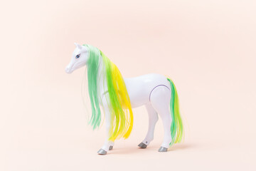 Toy plastic white horse on a pink background. Toy for a little girl. Horse for the princess.