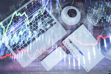 Financial market graph and top view computer on the desktop background. Double exposure. Investment concept.