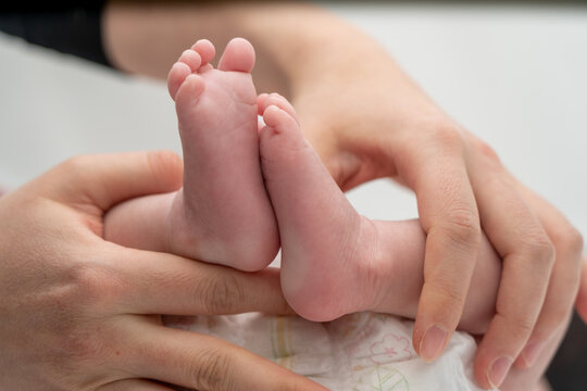 A baby's foot being held in a mother's hand_15