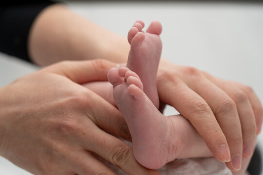 A baby's foot being held in a mother's hand_14
