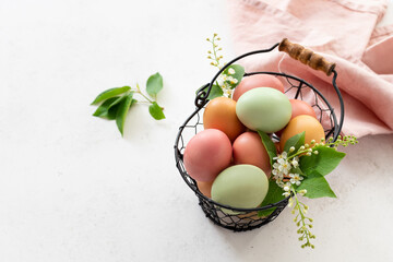 Pastel Easter eggs in a basket with spring flowers. natural egg dye from spices, vegetables. Happy...