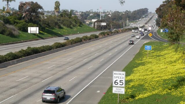 Cars on interstate highway 5, Oceanside California USA. Automobiles on intercity freeway. Auto transport in America. Road traffic and greenery near Los Angeles. Multiple lane thoroughfare from above.