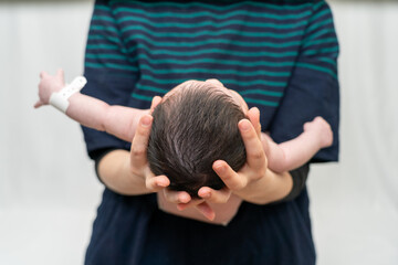 Naklejka premium Head of a baby being held by its mother_03