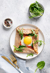 buckwheat crepe galette with egg, ham and spinach on gray background. Traditional French dish. vertical image. top view
