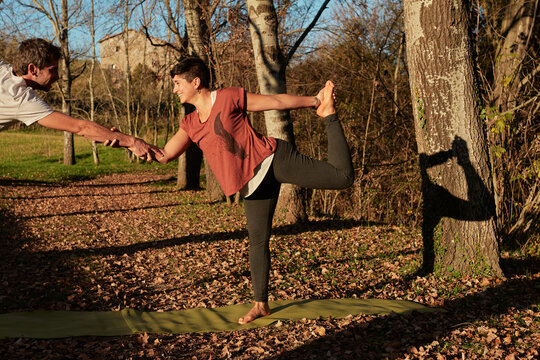 Couple In The Forest Practicing Yoga Balance