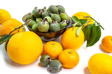 Ripe citrus fruits. Bright fresh fruit composition with foxes on a napkin. Orange, lemon, tangerine, feijoa, banana. Orange, yellow, green colors. Food market.