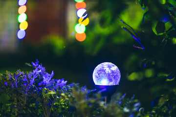Night View Of Flowerbed Illuminated By Energy-Saving Solar Powered Colorful Multi-colored Lantern...