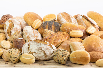 Many kinds and kinds of bread collected in one place on a wooden old shop counter as a decoration for a traditional bakery. White background from the top for self-completion.