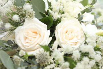 White roses with green leaves and other white flowers