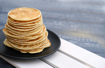 stack of classic american pancakes on a wooden rack. traditional family breakfast. comforting pancakes. front view. good morning concept.