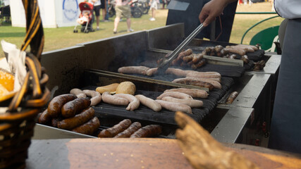 close up of a person working on a barbecue and grills.