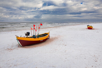 Fototapeta premium Fishing boats on snowy beach at Baltic sea in winter