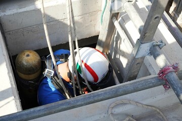Rescue officials are going down to the concrete tank to rescue workers in confined spaces.