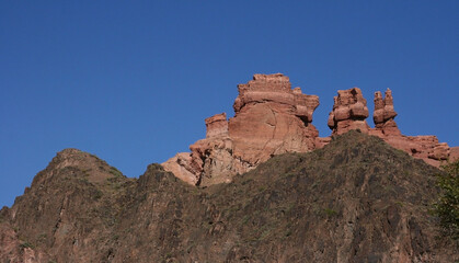 Fototapeta premium Charyn Canyon in South East Kazakhstan, summer 2019. Red rock canyon trail landscape. Trail in red rock canyon desert. Red rock canyon desert trail landscape. Yellow-red rocks of canyon in Kazakhstan.