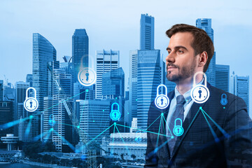 A young Caucasian cybersecurity developer thinking about new concepts at security compliance division to protect clients confidential information. IT lock icons over Singapore background.
