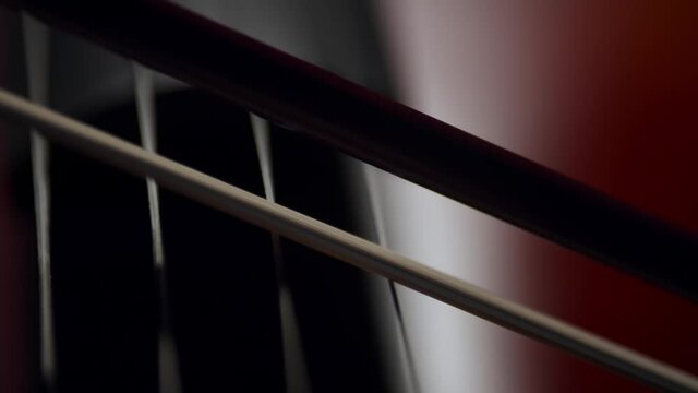 cello close-up on strings. Slow motion artistic macro bow plays on cello strings in an indoor classical symphony concert.