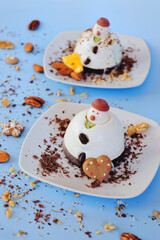 Ice cream background in the shape of two edible snowmen on white plates close up. Top view. Creative idea for Christmas and New Year festive desserts. Funny food idea for kids.
