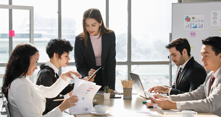 A Group of diverse businesspeople, Asan and Caucasian, make a conference together at the desk. Idea for good team at workplace © Bangkok Click Studio