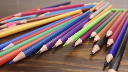 A set of colored pencils, stationery. A lot of multicolored pencils on the table.