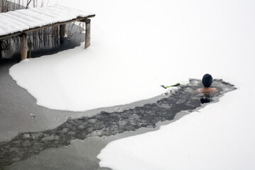 Zimowa kąpiel w zamarzniętym jeziorze - obrazy, fototapety, plakaty