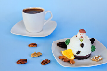Ice cream in the shape of edible snowman on white plate and coffee cup close up. Top view. Creative idea for Christmas and New Year festive desserts. Funny food idea for kids.