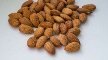 a handful of brown almonds on a white background