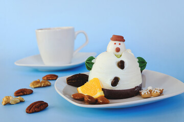Ice cream in the shape of edible snowman on white plate and coffee cup close up. Top view. Creative idea for Christmas and New Year festive desserts. Funny food idea for kids.