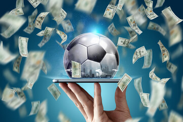 Online sports betting. Dollars are falling on the background of a hand with a smartphone and a soccer ball. Creative background, gambling.