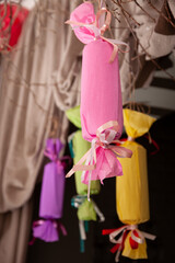 Conceptual handmade paper decorations hang from the ceiling. Candy ornaments and other accessories hang from the ceiling. Decorations and ideas for parties and celebrations.