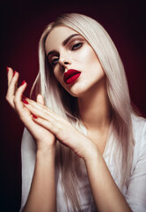 Blonde beautiful model posing with red manicure and lips