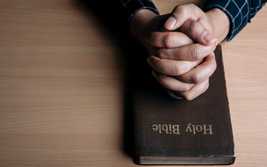 Christian life crisis prayer to god. Man Pray for god blessing to wishing have a better life. man hands praying to god with the bible. believe in goodness. Holding hands in prayer, eyes closed.