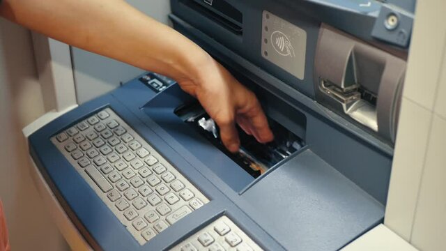 woman enters money into an ATM to replenish a bank account