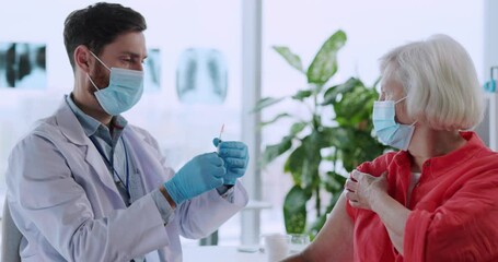 Quarantine concept. Young medical worker man injecting needle into female patient's arm doing vaccination injection due to coronavirus. - Powered by Adobe